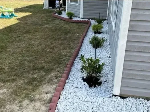 The same strip finished with white stone, red paver edging and new shrubs